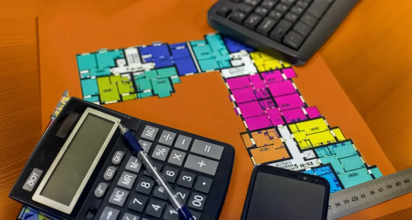 Construction loan calculator setup with floor plan, calculator, and tools used for estimating construction loan amount and project costs