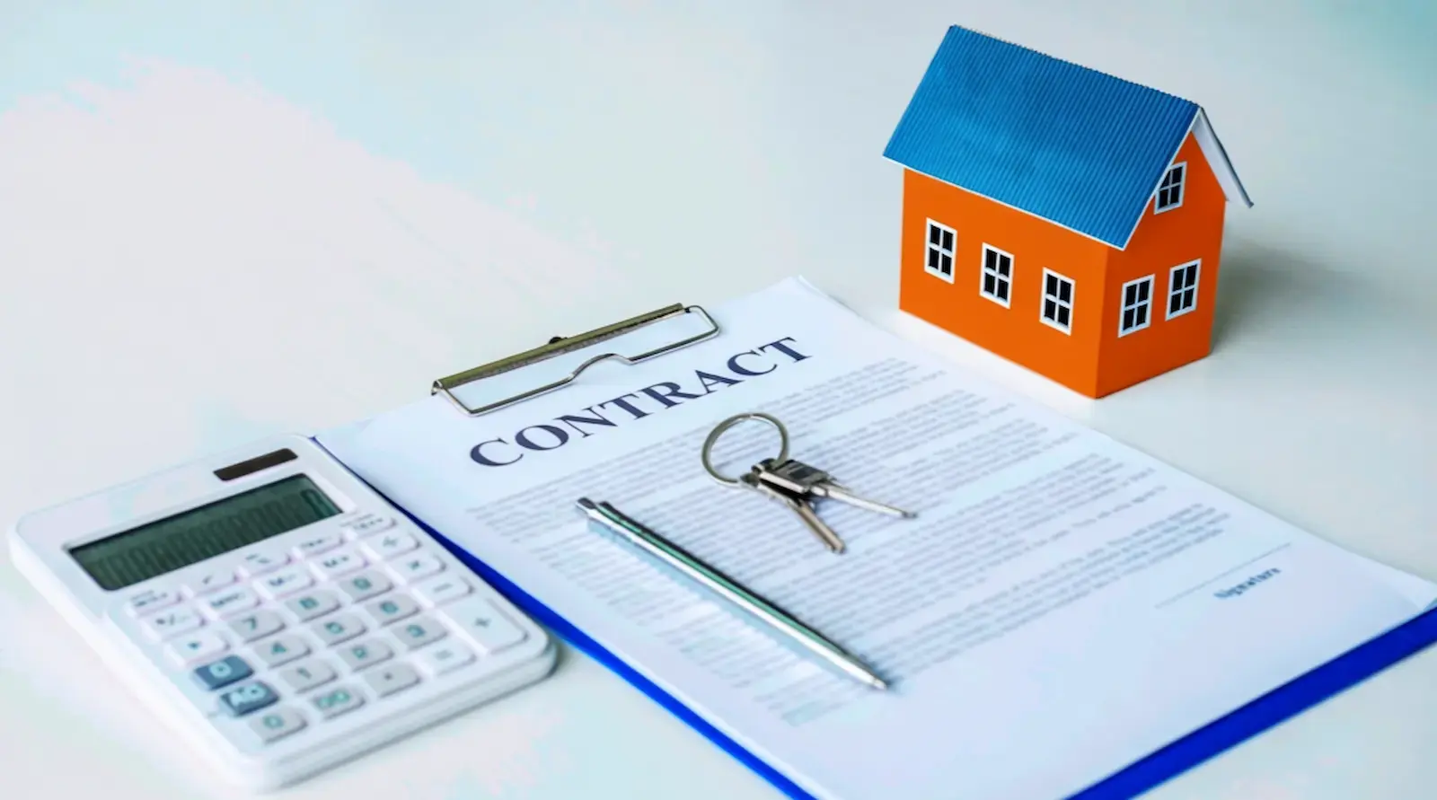 DSCR loan calculator next to a real estate contract, keys, and model house